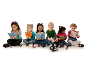 Six diverse children reading books.